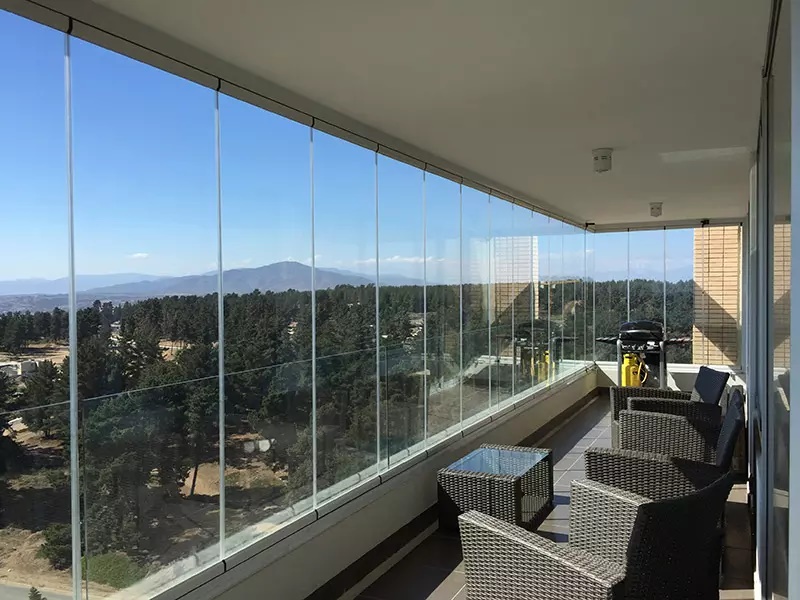 Sacada envidraçada com vista para a serra e área gourmet